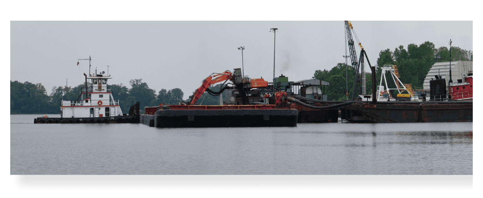 Tugboat moving a barge of dredged material on the James River